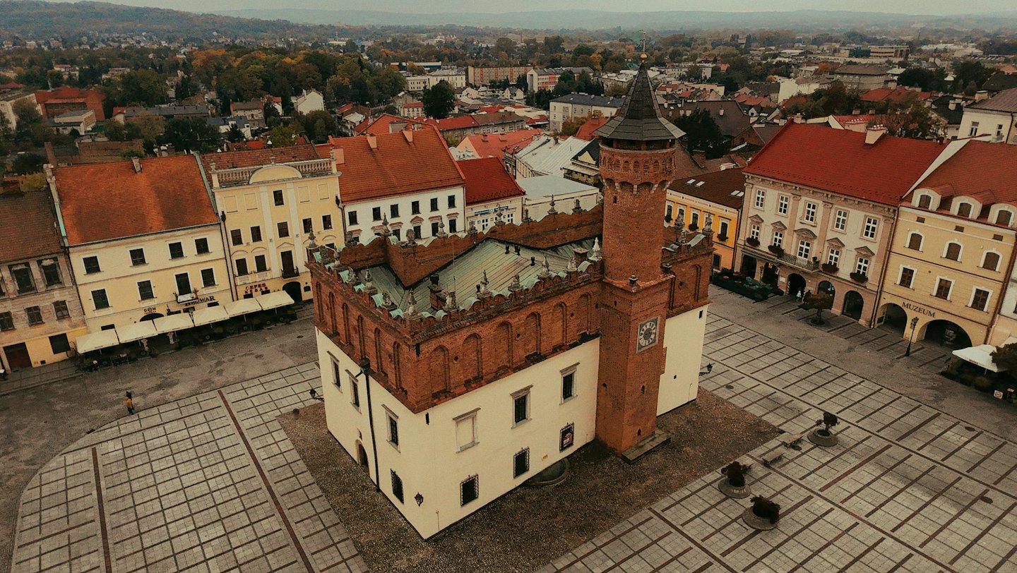 Eine einzelne Person geht über einen historischen europäischen Stadtplatz.